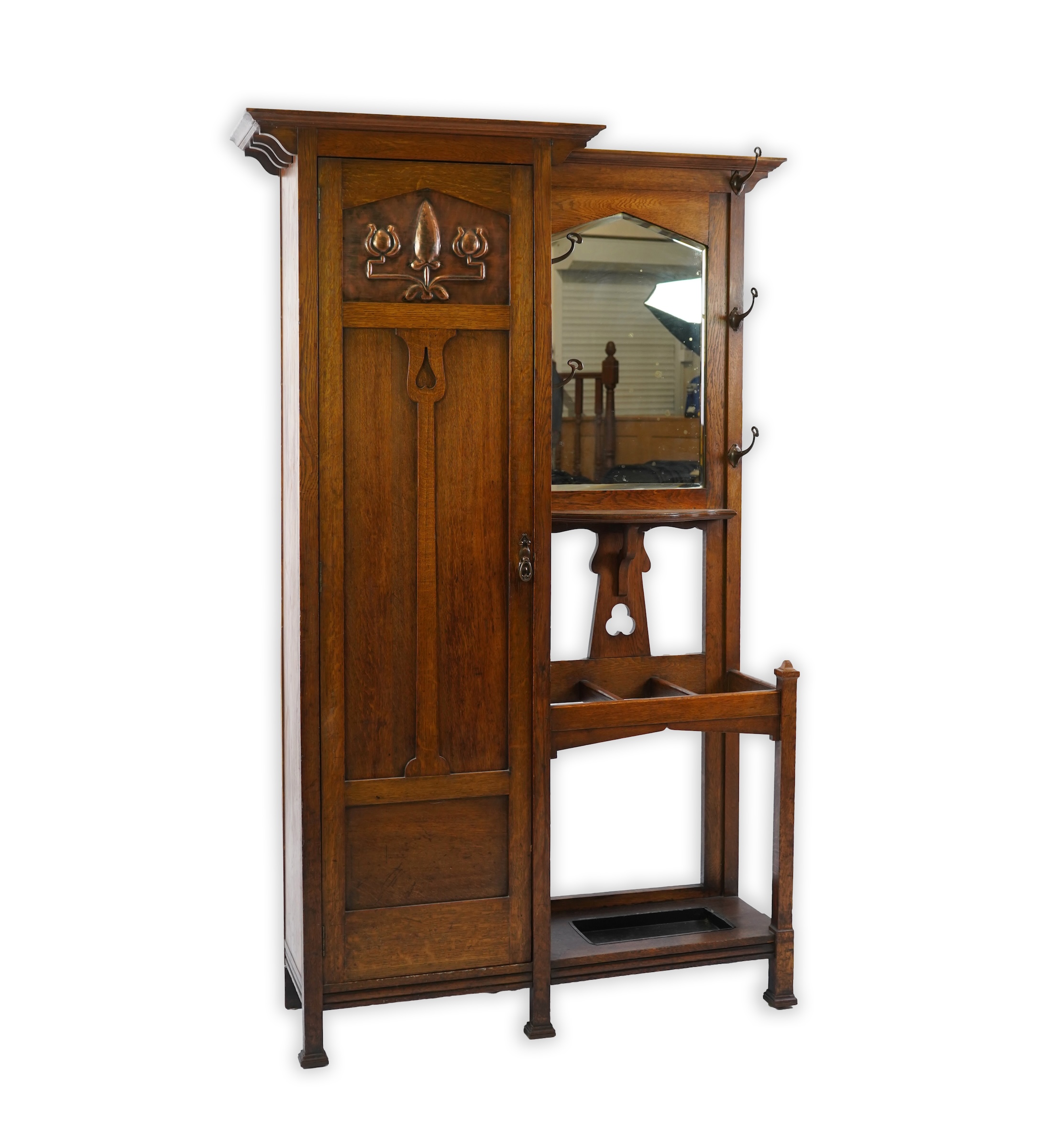 Manner of Liberty & Co: An Arts and Crafts embossed copper mounted oak hall cupboard